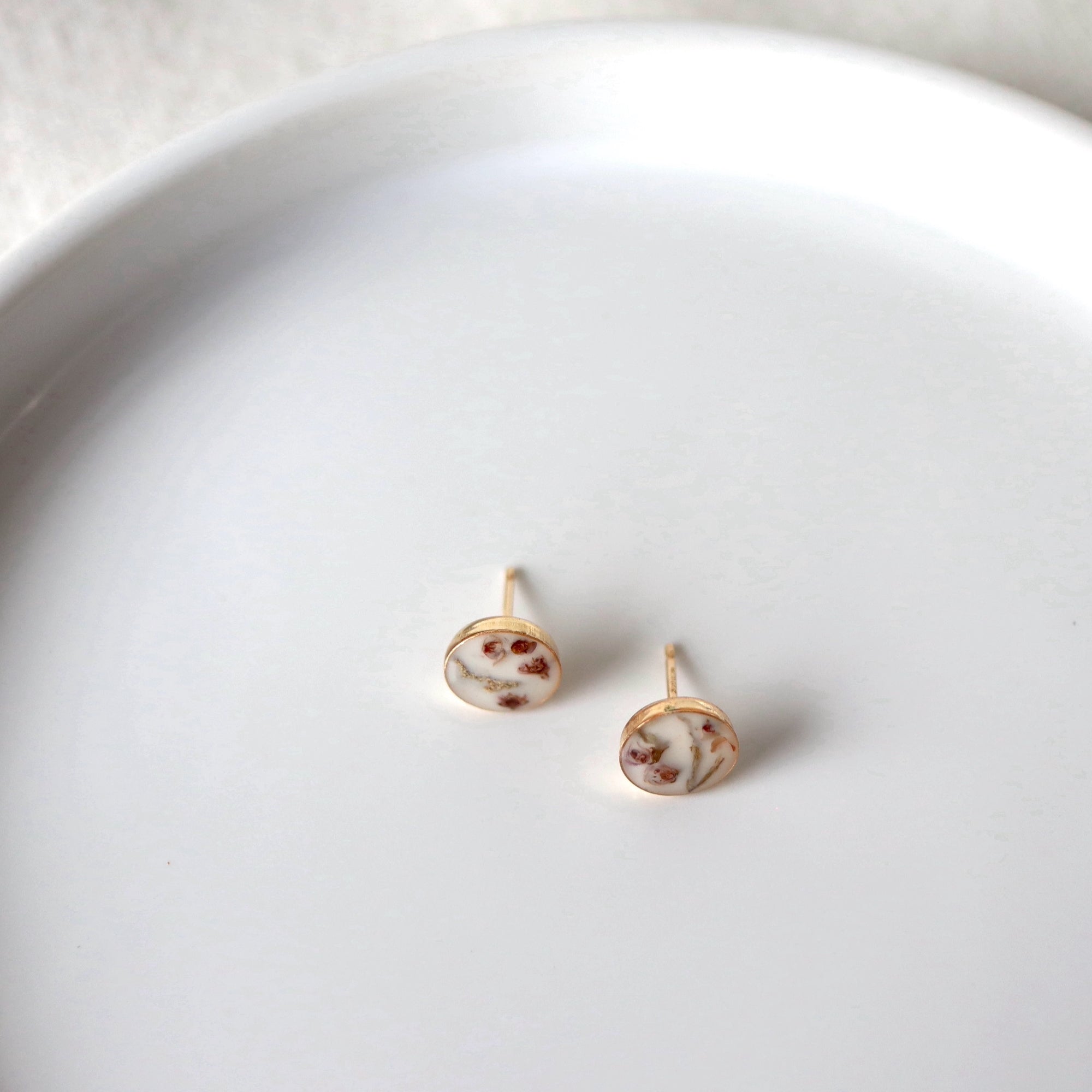 heather flower fragments sit inside 8mm gold earring stud cups. jewelry by Wild Blue Yonder Amber Aasman