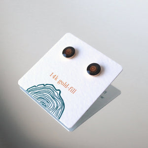 black and brown wood earrings sit against a soft white background. 